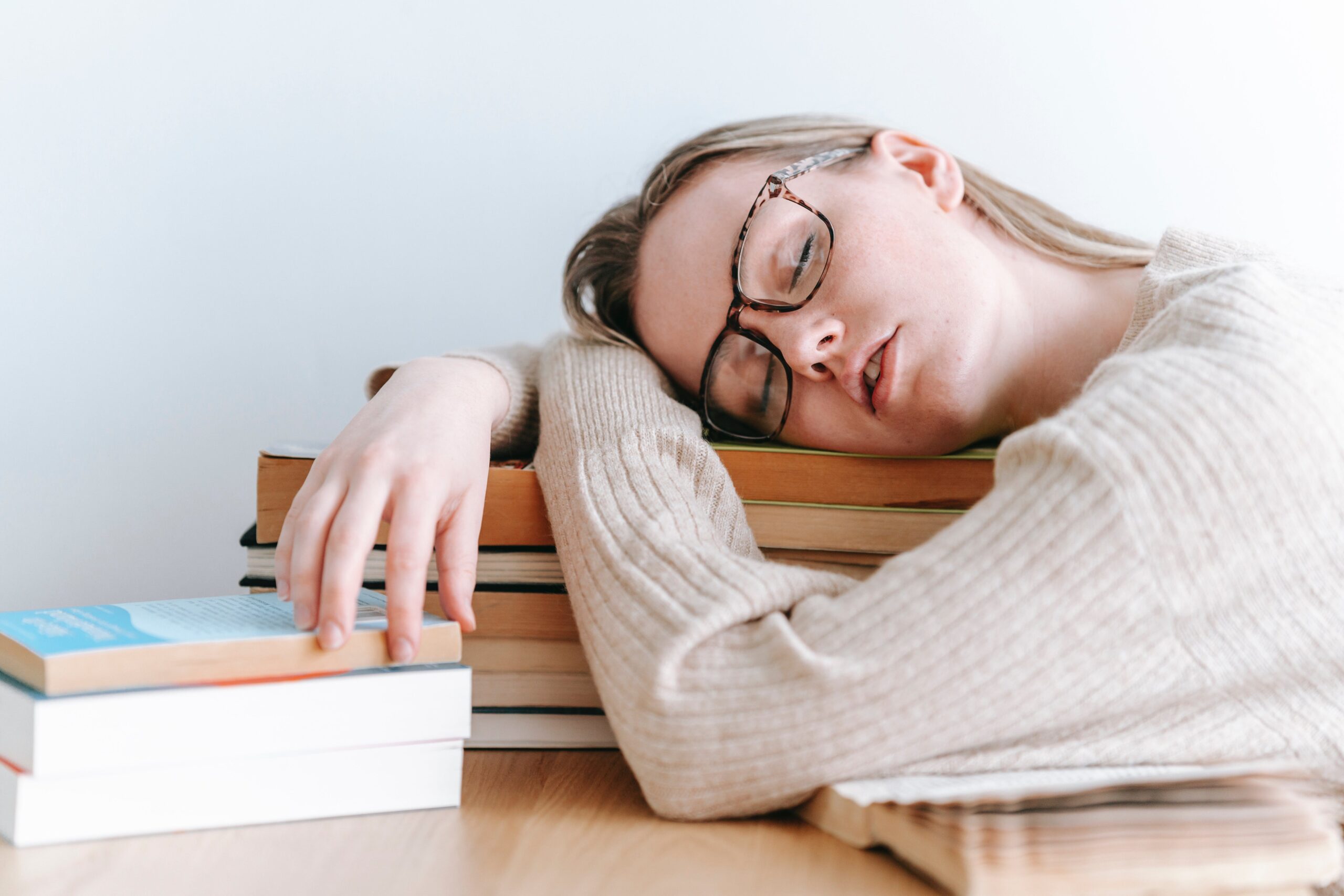 Uticaj samoregulacije, studentkinja spava za stolom, primer prokrastinacije